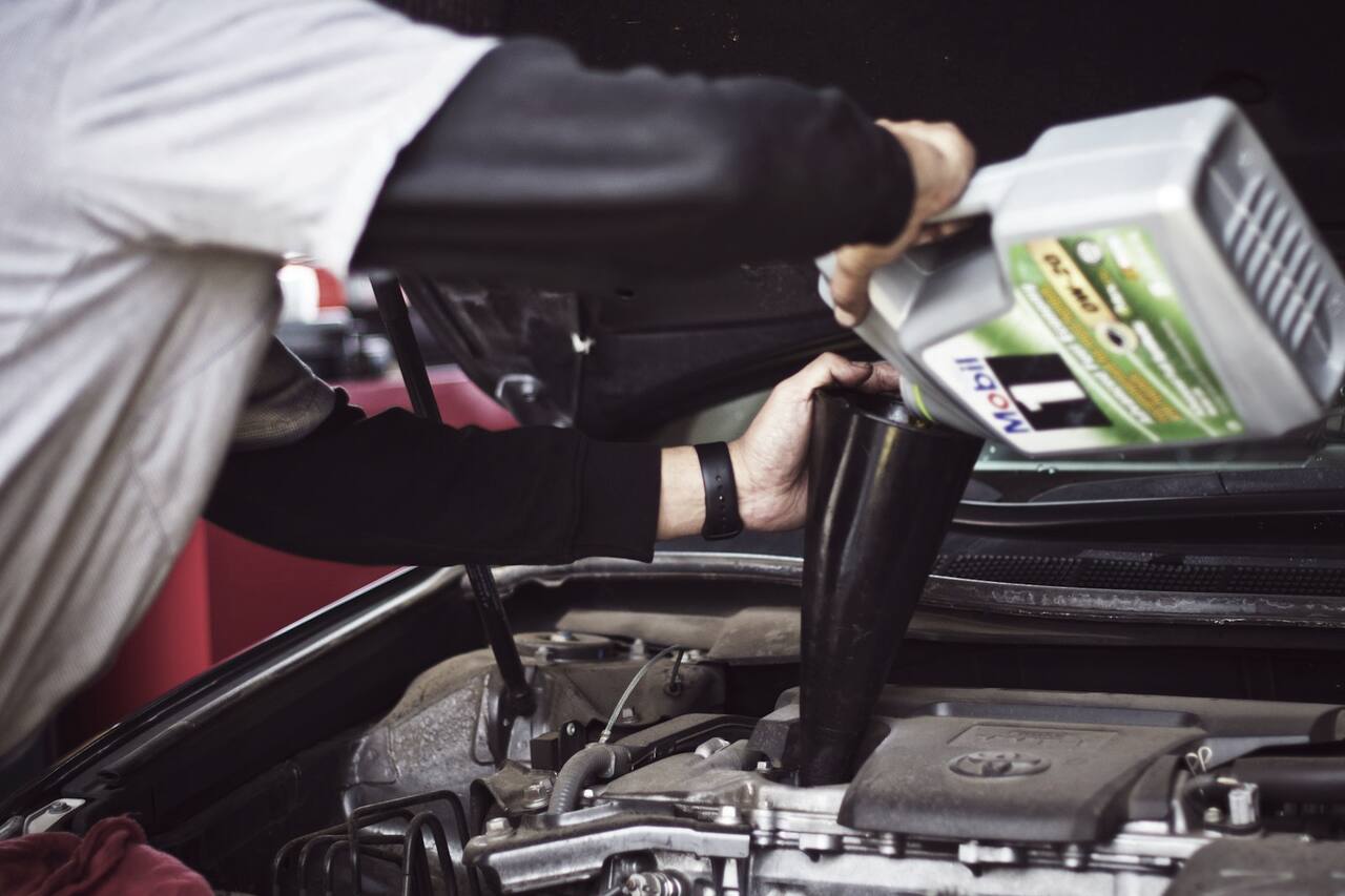 A service technician working under the hood at the truck